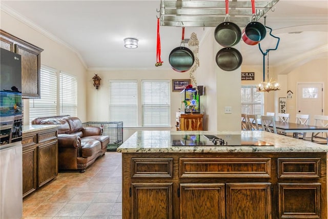 kitchen featuring ornamental molding, plenty of natural light, black electric cooktop, and a notable chandelier