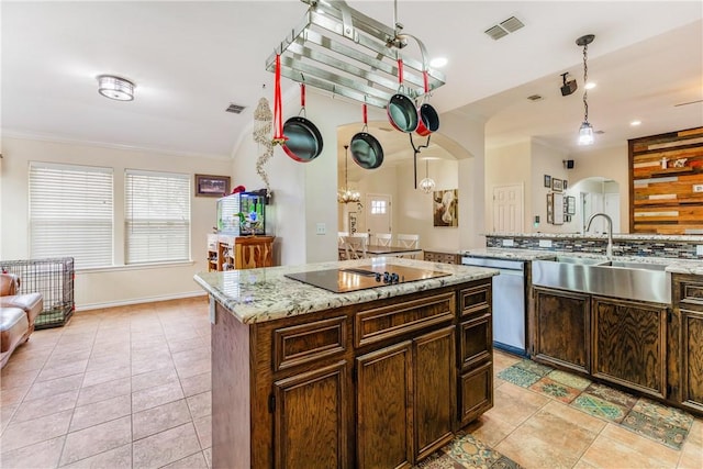 kitchen featuring visible vents, dishwasher, decorative light fixtures, a center island, and a sink