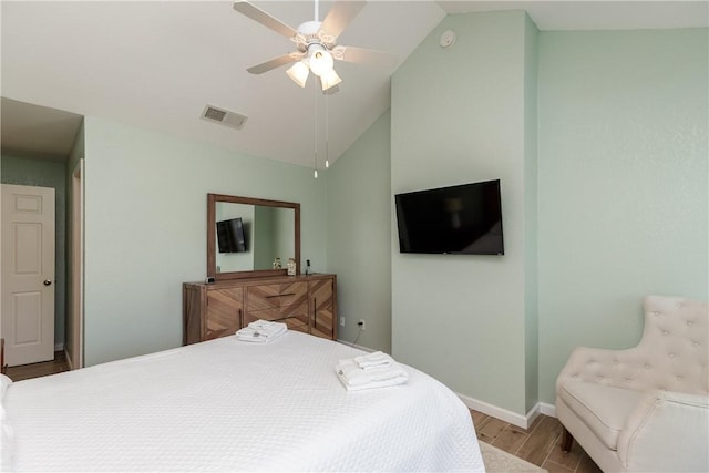 bedroom with wood finished floors, vaulted ceiling, baseboards, and a ceiling fan