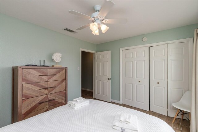 bedroom with a closet, a ceiling fan, wood finished floors, and baseboards