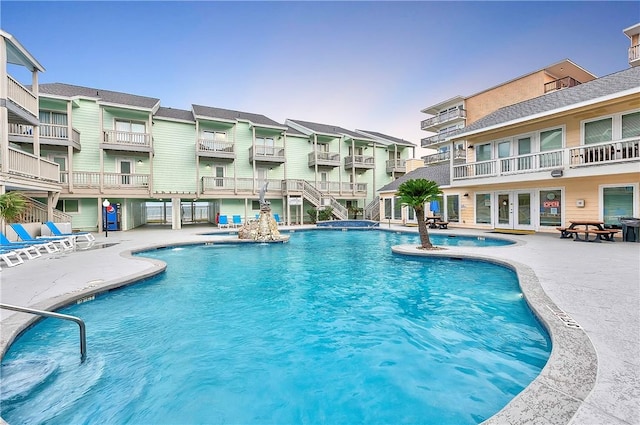 community pool featuring a hot tub and a patio area