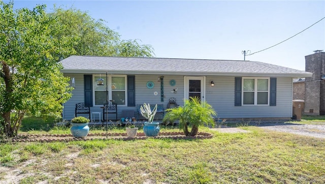 ranch-style home with covered porch and a front lawn