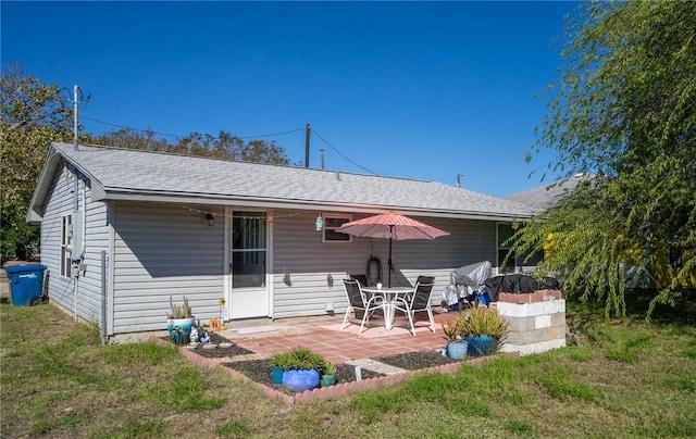 rear view of property featuring a lawn and a patio