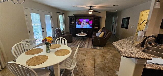 kitchen featuring sink, light stone counters, pendant lighting, light tile patterned flooring, and appliances with stainless steel finishes