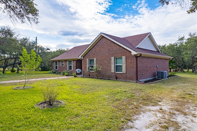 view of front of home with a front yard and cooling unit