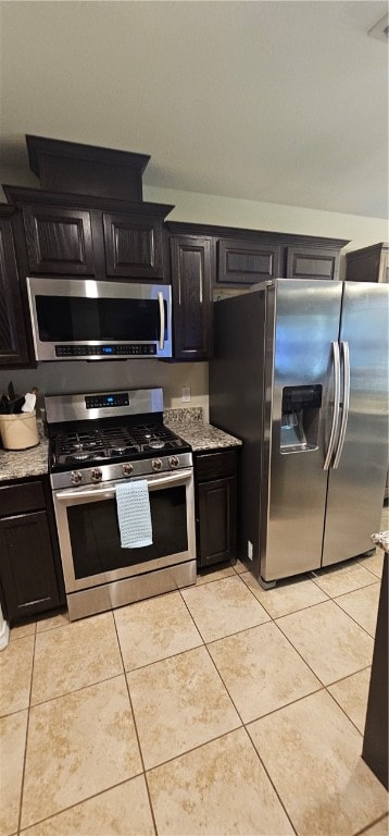 kitchen featuring light stone countertops, light tile patterned floors, and appliances with stainless steel finishes