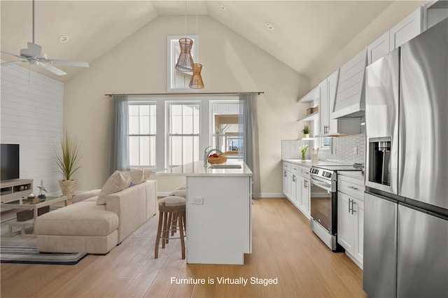 kitchen featuring white cabinetry, appliances with stainless steel finishes, an island with sink, and light hardwood / wood-style floors