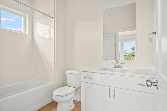 full bathroom with hardwood / wood-style floors, a healthy amount of sunlight, toilet, and tiled shower / bath combo