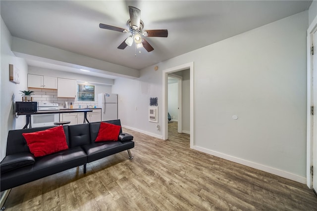 living room featuring ceiling fan and light hardwood / wood-style flooring