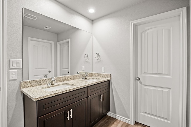 2689 Everly Ln, Corpus Christi, TX 78415 - bathroom with double vanity, wood finished floors, and baseboards