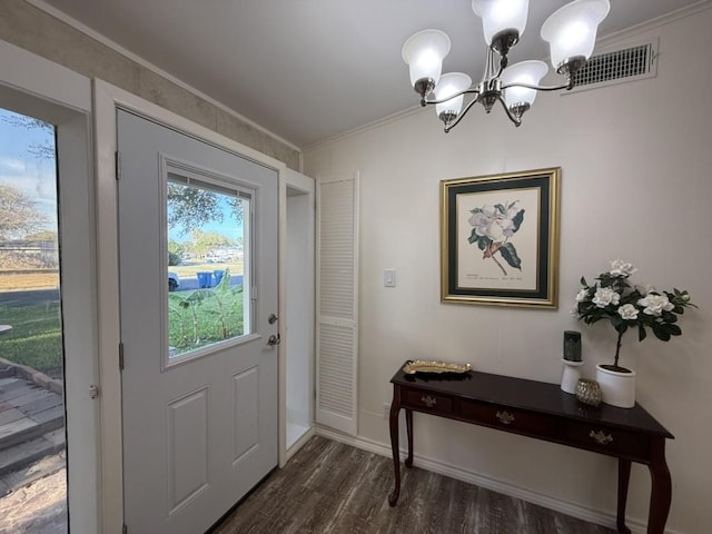 doorway featuring a notable chandelier, crown molding, and dark hardwood / wood-style flooring