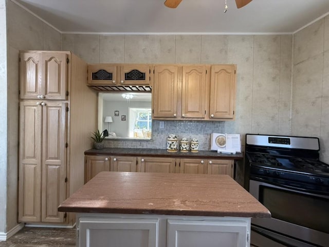 kitchen with stainless steel gas stove, a center island, ceiling fan, light brown cabinetry, and decorative backsplash