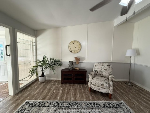 living area featuring ceiling fan and dark hardwood / wood-style flooring