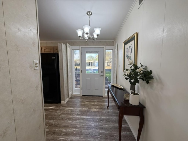 foyer featuring an inviting chandelier, ornamental molding, and dark hardwood / wood-style floors