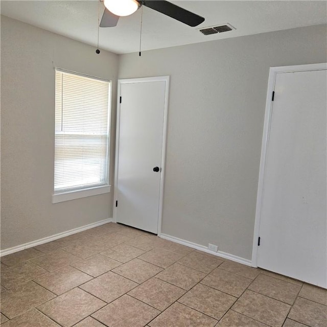 4749 Mokry Dr, Corpus Christi, TX 78415 - empty room with a ceiling fan, light tile patterned floors, and baseboards