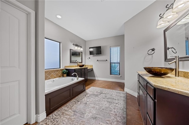 bathroom featuring tile patterned floors, a tub to relax in, and vanity