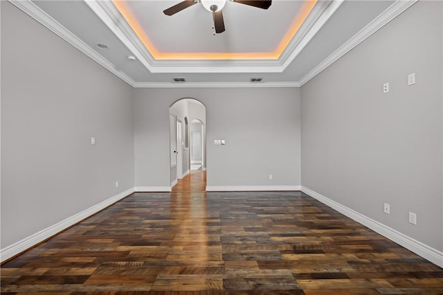 unfurnished room featuring dark hardwood / wood-style flooring, ornamental molding, and a tray ceiling