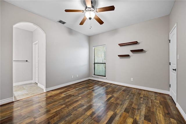 spare room featuring ceiling fan and dark wood-type flooring