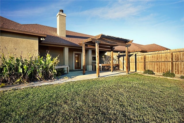 back of house featuring a lawn, a patio area, and a pergola