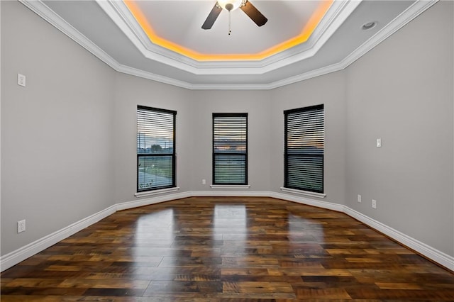 spare room featuring ceiling fan, dark wood-type flooring, ornamental molding, and a tray ceiling