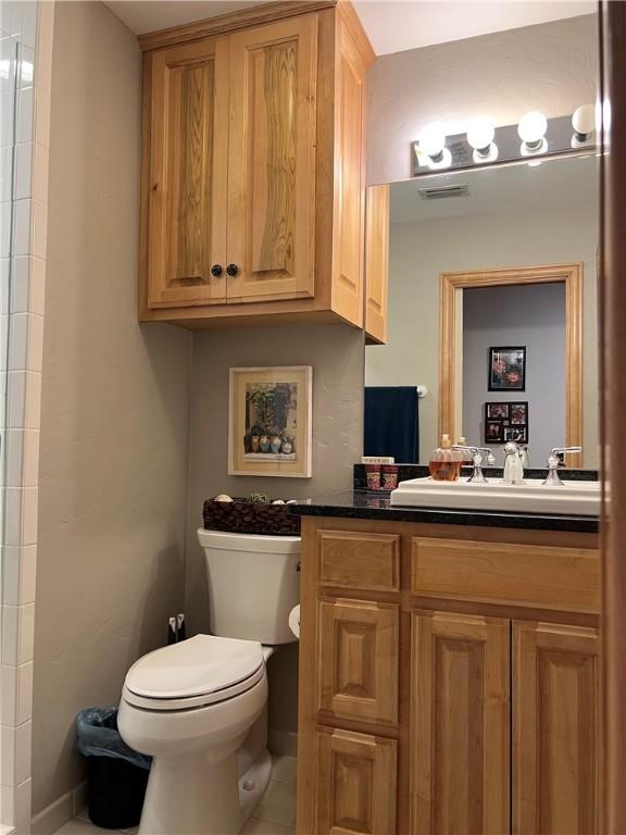 1504 Morningside Dr, Alice, TX 78332 - bathroom featuring toilet, vanity, tile patterned flooring, and baseboards