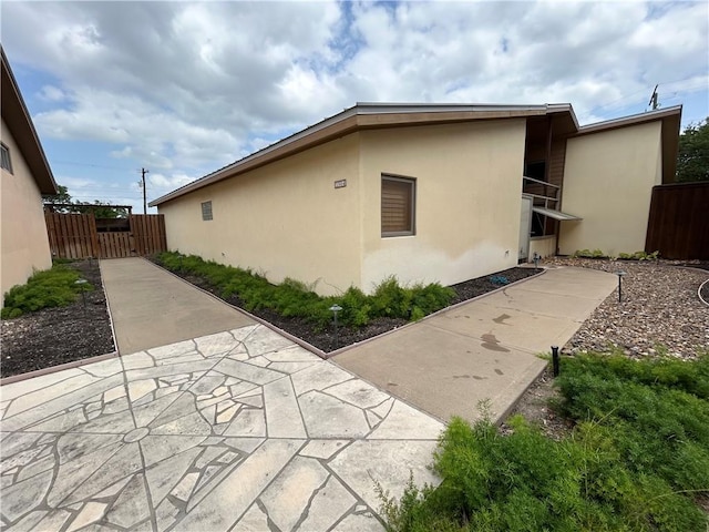 1504 Morningside Dr, Alice, TX 78332 - view of side of property with stucco siding, fence, and a patio area