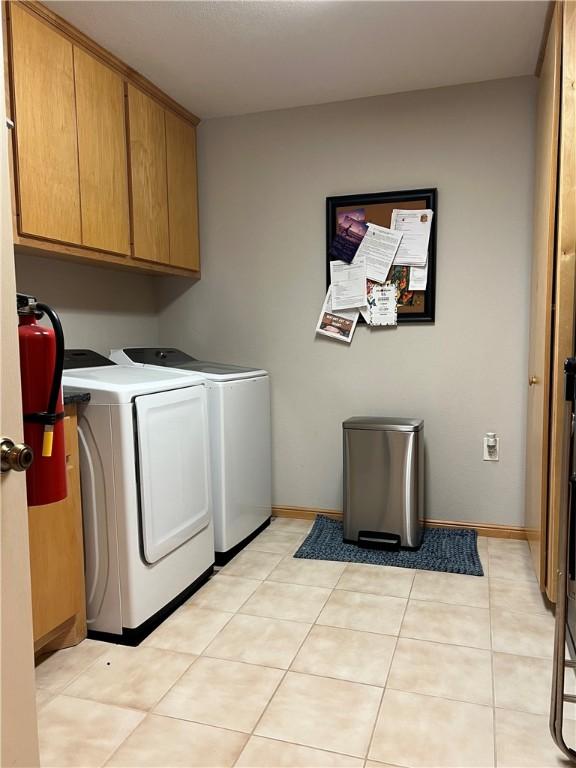 1504 Morningside Dr, Alice, TX 78332 - laundry area featuring cabinet space, washer and clothes dryer, light tile patterned flooring, and baseboards