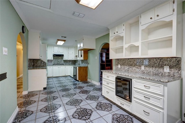 kitchen with beverage cooler, dishwasher, white cabinetry, backsplash, and light stone counters