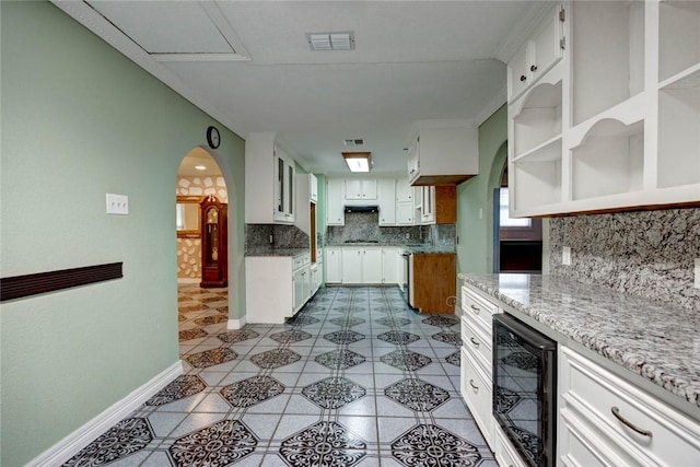 kitchen featuring white cabinets, decorative backsplash, and wine cooler