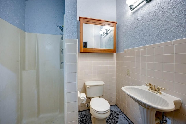 bathroom featuring tile walls, toilet, and walk in shower