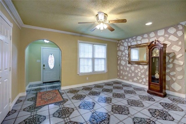 entrance foyer with a textured ceiling, ceiling fan, and ornamental molding