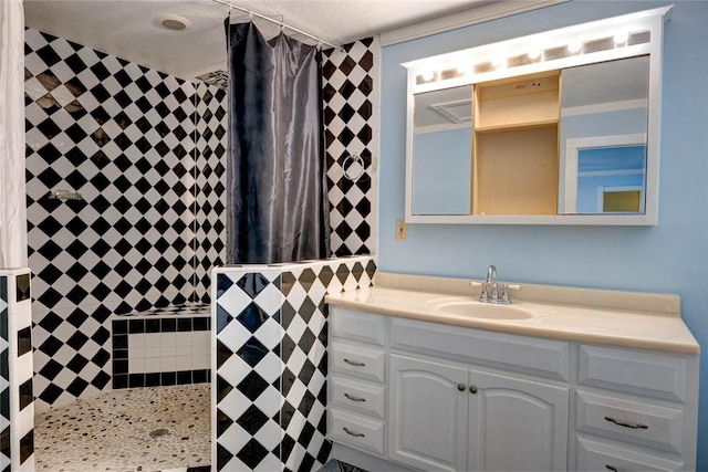 bathroom with a textured ceiling, walk in shower, and vanity