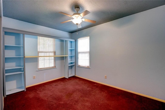 carpeted empty room with ceiling fan and a textured ceiling