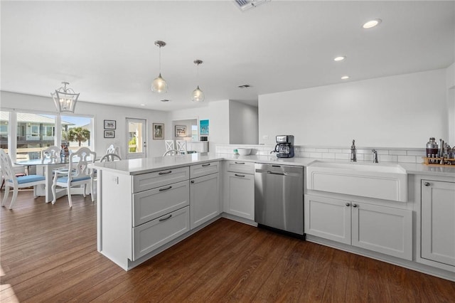 kitchen featuring a sink, dark wood-type flooring, dishwasher, and light countertops