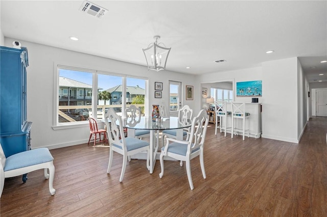 dining area with baseboards, dark wood-style flooring, visible vents, and an inviting chandelier