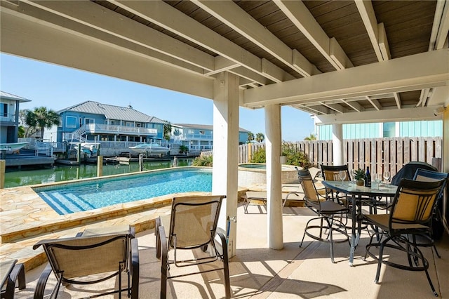 view of pool with a fenced in pool, a patio area, fence, and a water view