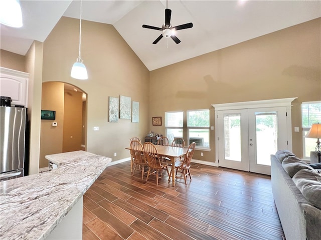 dining space with french doors, dark hardwood / wood-style floors, high vaulted ceiling, and ceiling fan