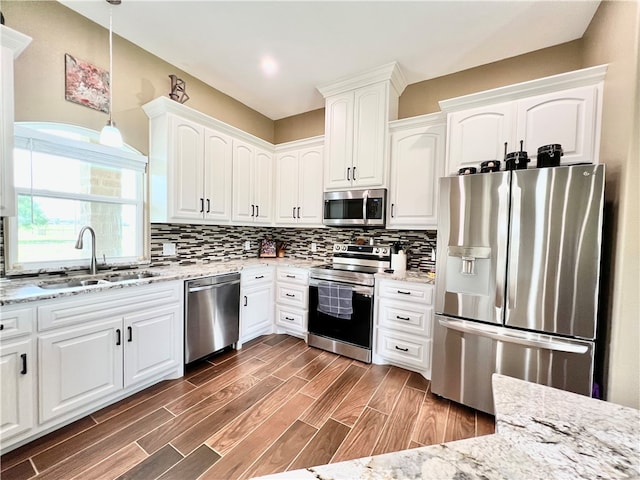 kitchen featuring sink, stainless steel appliances, dark hardwood / wood-style floors, decorative light fixtures, and white cabinets