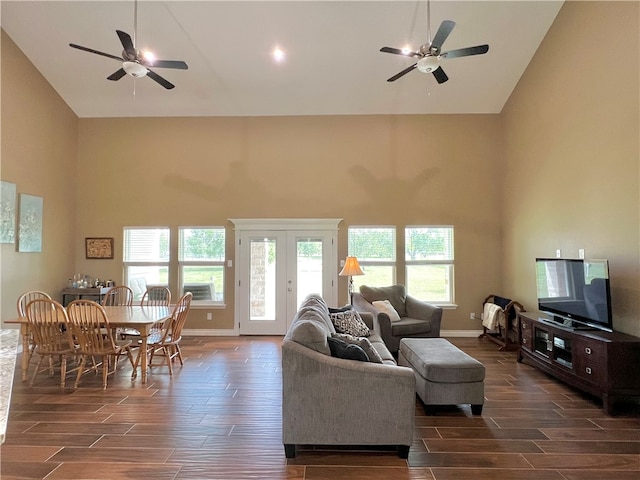 living room with high vaulted ceiling, ceiling fan, and dark wood-type flooring