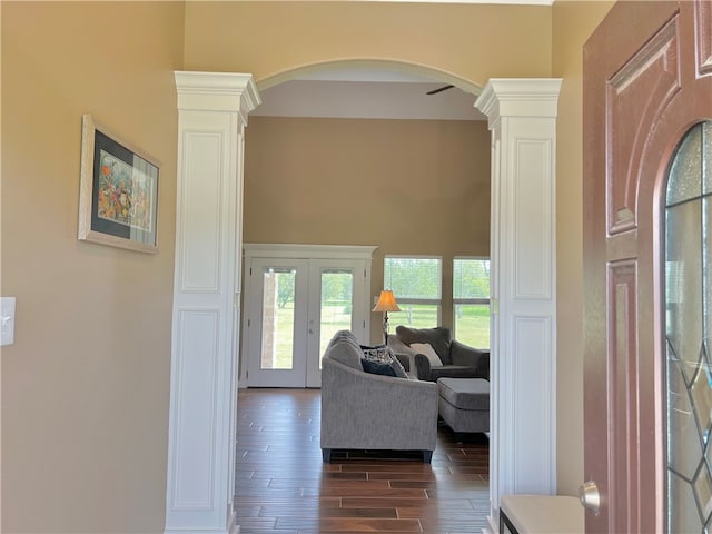 interior space featuring ornate columns, dark hardwood / wood-style flooring, and french doors