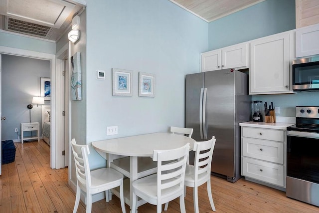 kitchen featuring visible vents, appliances with stainless steel finishes, light countertops, light wood-style floors, and white cabinetry