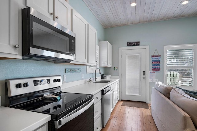 kitchen featuring white cabinets, wooden ceiling, stainless steel appliances, light countertops, and a sink