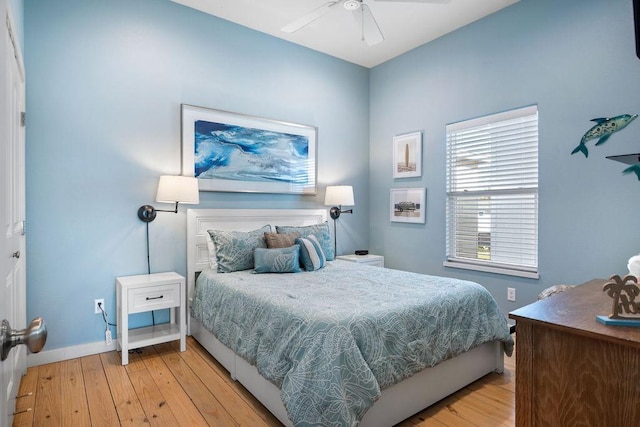 bedroom with light wood-type flooring, ceiling fan, and baseboards