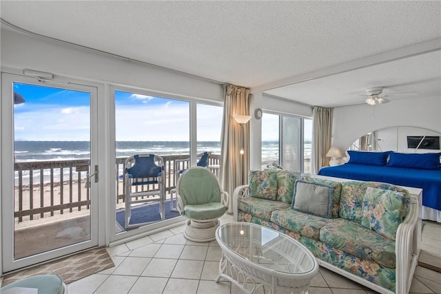 14810 Windward Dr Unit 509, Corpus Christi, TX 78418 - tiled bedroom featuring access to outside, a textured ceiling, multiple windows, a view of the beach, and ceiling fan
