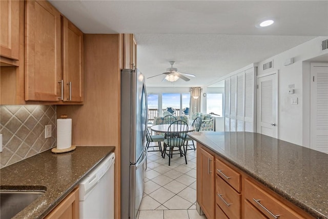14810 Windward Dr Unit 509, Corpus Christi, TX 78418 - kitchen with freestanding refrigerator, white dishwasher, ceiling fan, light tile patterned floors, and decorative backsplash