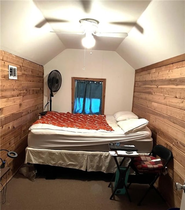 bedroom featuring wood walls, ceiling fan, and vaulted ceiling