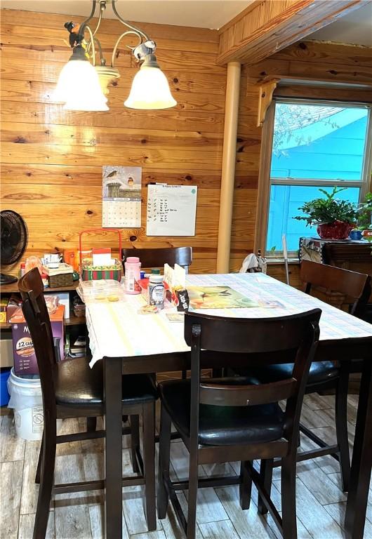 dining room featuring wood-type flooring and wooden walls