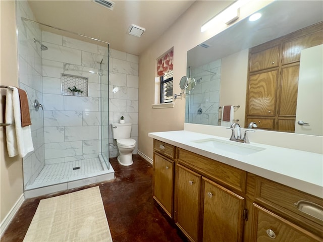 bathroom featuring vanity, toilet, and a tile shower