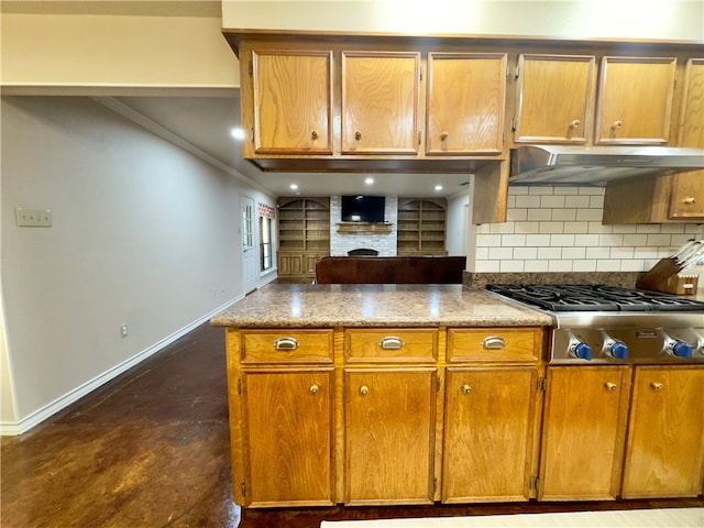 kitchen with backsplash, stainless steel gas cooktop, crown molding, and dark stone countertops