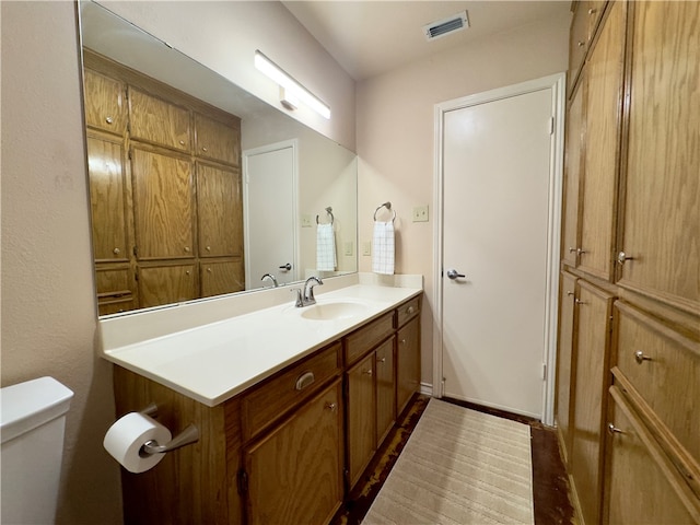 bathroom featuring hardwood / wood-style floors, vanity, and toilet